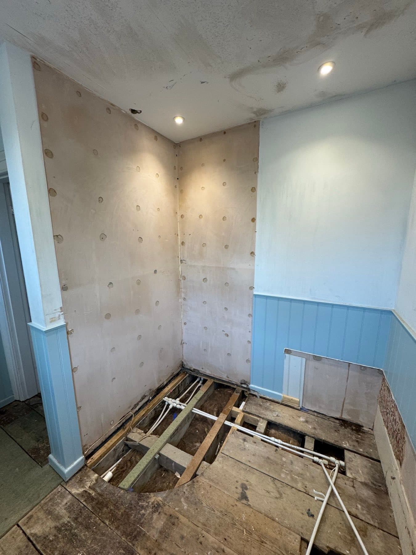 Bathroom at first fix with bare plasterboard and new pipework before boarding and tanking