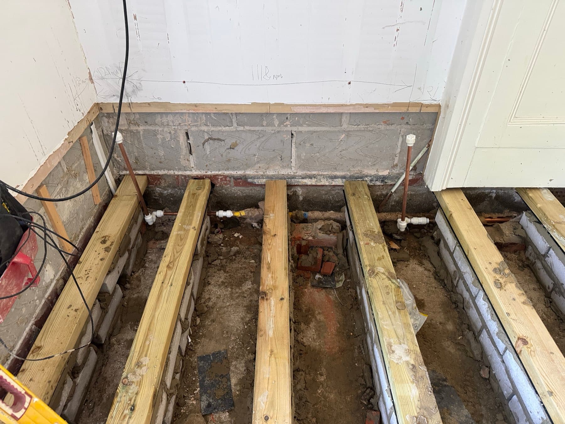 First-fix copper pipework between the floor joists of an extension