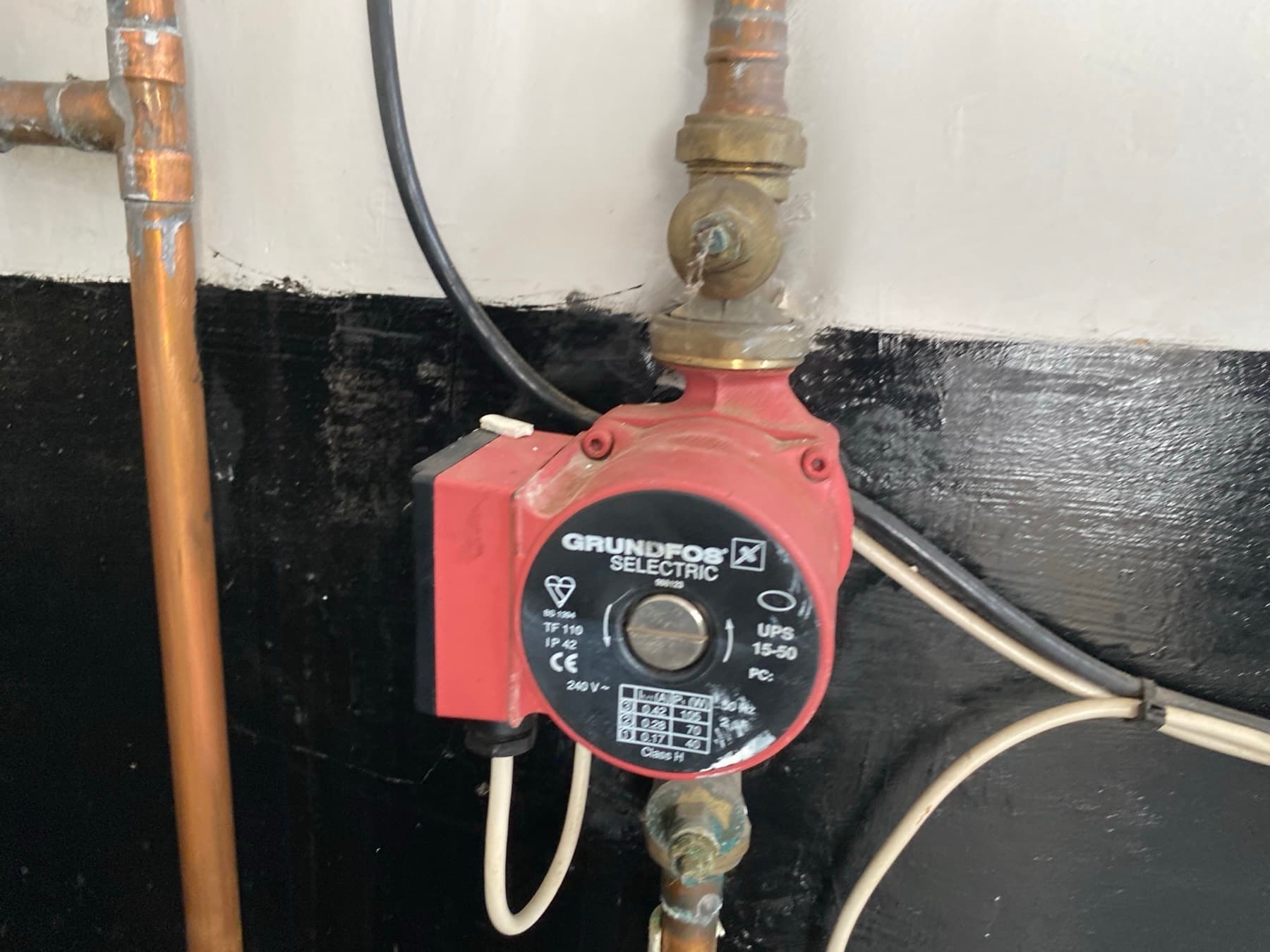 Grundfos UPS 15-50 circulating pump on copper heating pipework with a gate valve above it