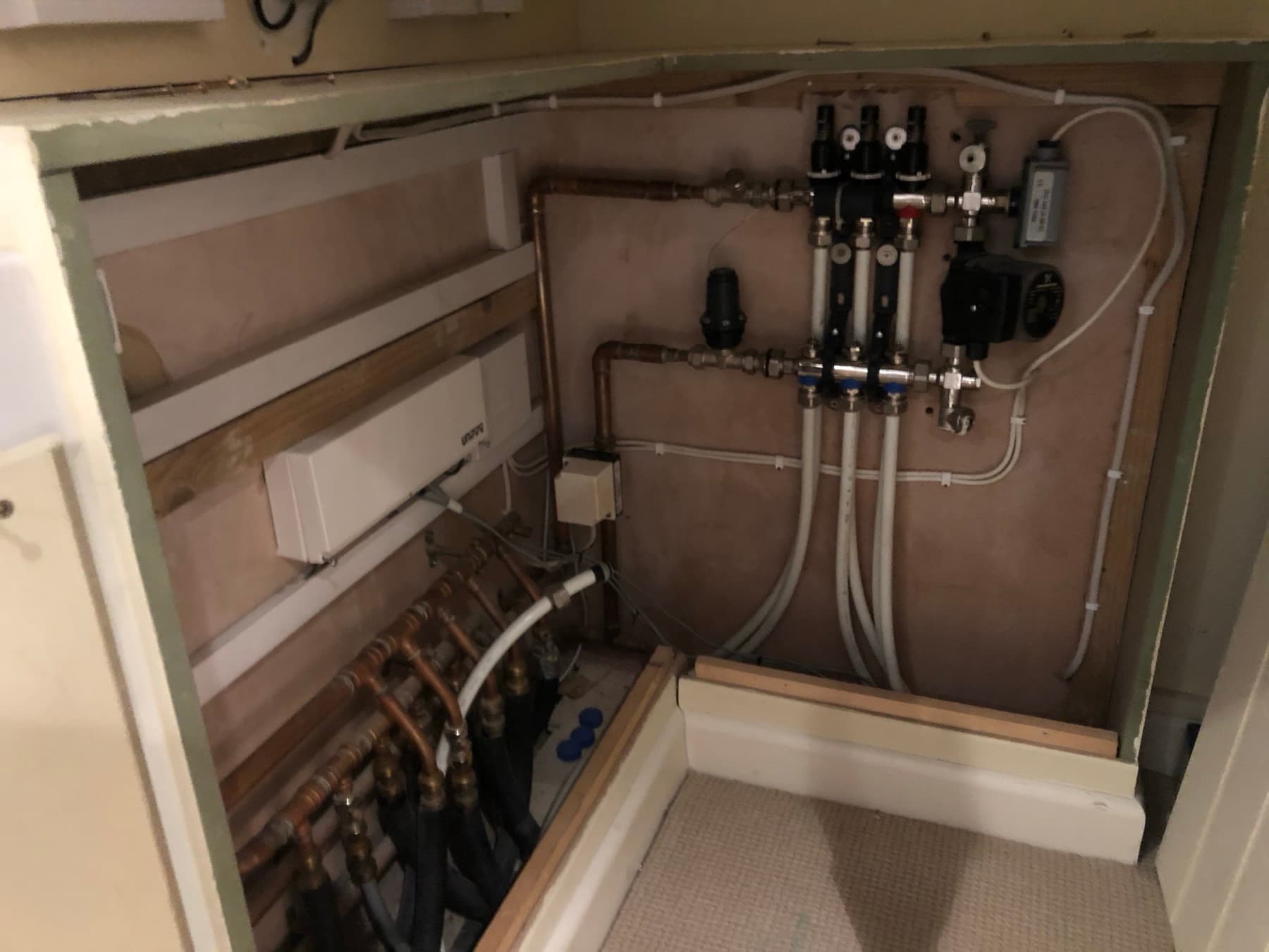 Underfloor heating manifold in a cupboard with circulating pump, blending valve and flow meters