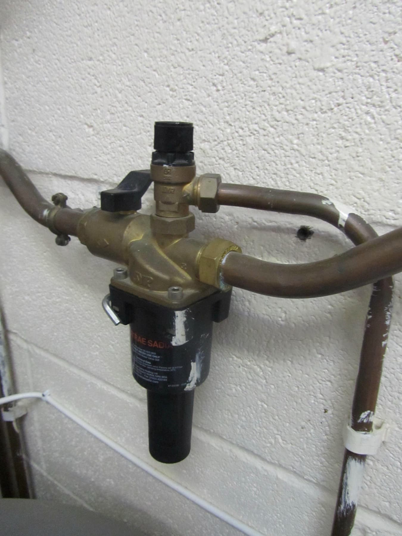 Pressure reducing valve with a strainer on the cold feed to a hot water cylinder