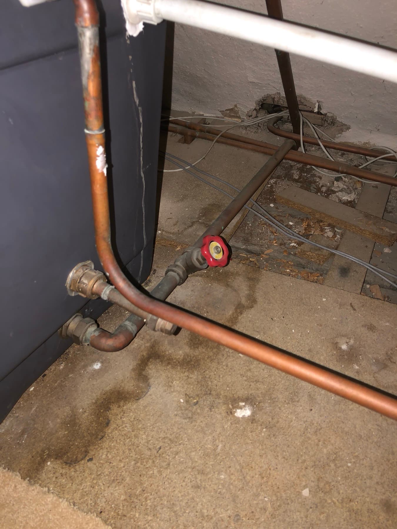 Damp patch spreading across a ceiling below a failed cold water tank connector