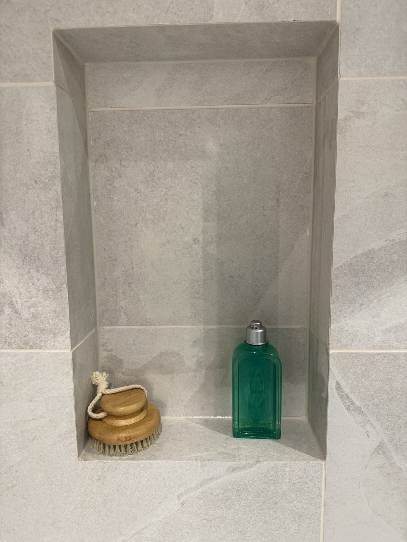 Recessed tiled niche built into a shower wall for bottles