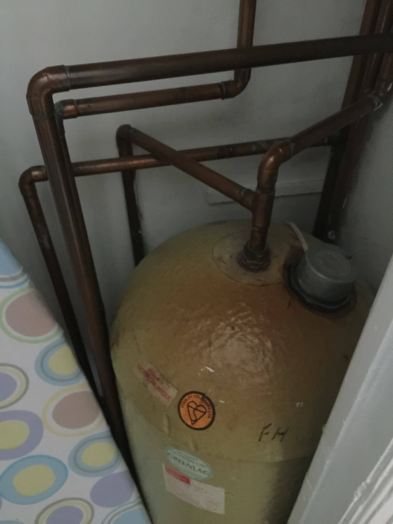 An old copper cylinder with bare pipework — the kind that gets replaced