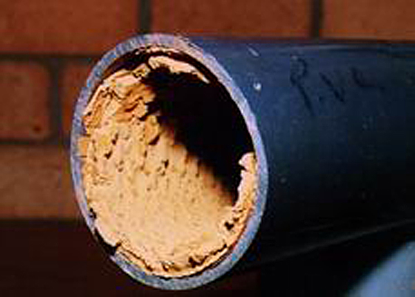 Limescale buildup inside water pipes restricting flow